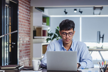 Wall Mural - asian businessman woking with laptop and paper work on desk  at office.digital workflow online business lifestyle concept.