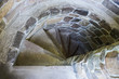 © anastasiia agafonova - stone spiral staircase with descent down steps and brick wall in castle tower, horizontal stock photo image background with copy space for text