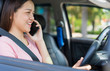 © Joke Phatrapong - Happy young Asian girls using or talking smart phone while driving the car. Dangerous driver, transportation and vehicle or Road safety concept