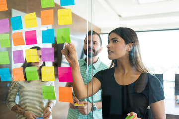 Wall Mural - Colleagues Planning Over Adhesives With Team In Workplace