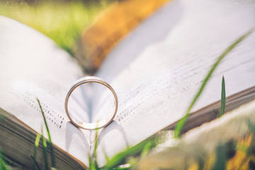 Golden engagement ring and old book. Background for a romantic wedding card