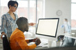 © Seventyfour - Side view portrait of two modern young people looking at blank white computer screen while working on startup project in office, copy space
