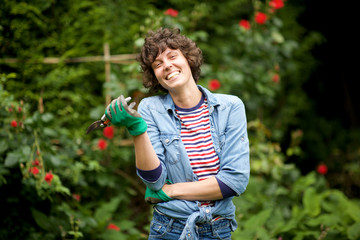 Wall Mural - laughing female gardener standing with scissors in garden