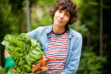 Wall Mural -  female farmer with bunch of vegetables in basket