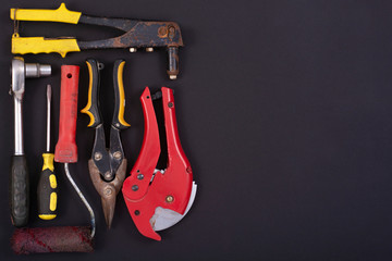 Hand tools on a black background. Free space for an inscription.