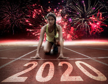 2020 New Year Celebration On The Racing Lane With Young Female Athlete At Starting Block