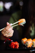 © F8  \ Suport Ukraine - Hands eat sushi with chopsticks in cafe