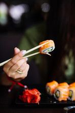 Hands Eat Sushi With Chopsticks In Cafe