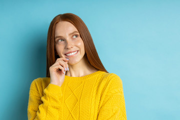 Studio shot of redhead caucasian young woman isolated blue background