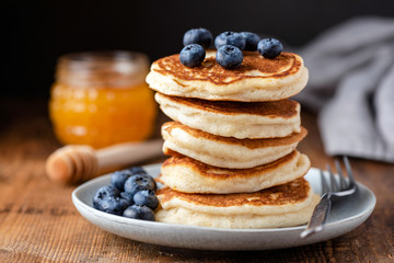 Wall Mural - Stack of pancakes with blueberries on a wooden table. Tasty breakfast buttermilk pancakes, american cuisine