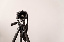 Professional DSLR Camera On A Tripod Isolated On Gray Background With Copy Space
