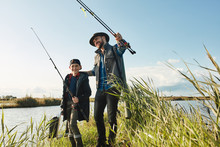 Father Took Son For First Joint Fishing. Father Going To Tell How To Fish, Use Fishing Rod And Fishing Hooks.