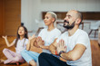 © alfa27 - Young caucasian parents with child meditating at home isolated in room , sitting on floor. Family, sport, yoga concept. White colors