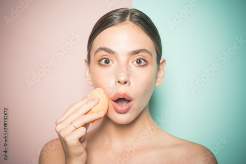 Fotografía Beautiful girl applies natural makeup foundation with sponge