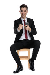 Sticker - Handsome businessman pointing forward and holding his phone