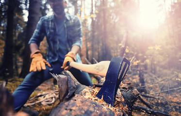 Canvas Print - Male worker with an ax chopping a tree in the forest.