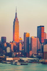 Fototapete - Manhattan skyline illuminated by sunset