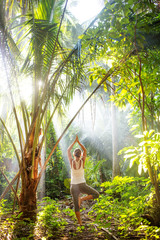 Canvas Print - woman doing yoga outside in jungle