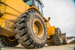 © Jason - Focus on the black rubber wheels of a yellow bulldozer at a construction site