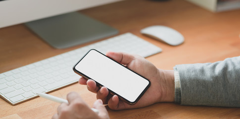 Close-up view of professional businessman looking at his blank screen smartphone