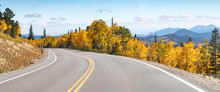 Empty Road Winds Through A Panoramic Mountain Landscape Scene With Golden Fall Aspen Trees In The Colorado Mountains