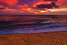 Beautiful Vibrant Dramatic Cloudy Sky Winter Sunset On A Sandy Textured Beach.