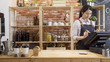 waitress girl in apron using finger touching screen of POS terminal in coffee shop. young woman staff in coffeehouse checking on tablet with software interface to take order and print receipt in cafe