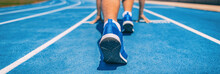 Sprinter Fit Man Waiting For Start Of Race On Running Tracks At Outdoor Stadium. Sport And Fitness Runner Athlete On Blue Run Track Starting Line With Running Shoes. Banner Panorama.