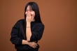 © Ranta Images - Young beautiful Asian woman wearing black sweater against brown