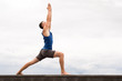© Natalia Navodnaia - attractive young man doing yoga warrior pose on the beach on sky background