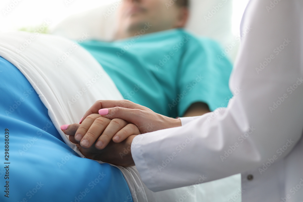 Female doctor hands hold male arm in medical hospital - obrazy, fototapety, plakaty 