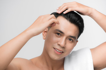 Poster - beauty, grooming and people concept - smiling young man brushing hair with comb over white background