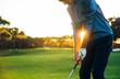 canvas print picture - Male golf player teeing off golf ball from tee box to beautiful sunset