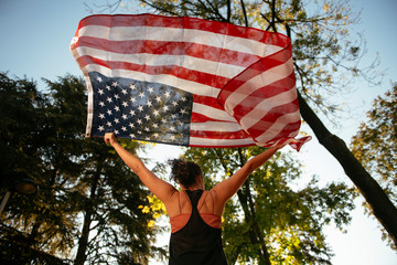 Athletic young woman with american flag. 