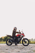 © Photocreo Bednarek - Woman standing on roadside with a motorbike. Motorcycle trip