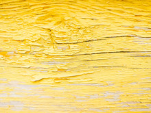 Wood Texture With Yellow Flaked Paint. Peeling Paint On Weathered Wood. Old Cracked Paint Pattern On Rusty Background. Chapped Paint On An Old Wooden Surface