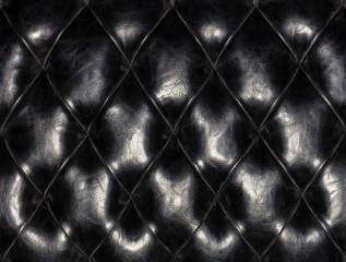 Old black furniture leather, background and texture of stitched with threads.