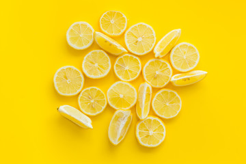 Lemon slices on yellow background top view