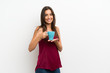 © luismolinero - Young woman over isolated white background holding hot cup of coffee
