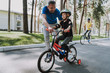 © Yakobchuk Olena - Joyful father teaching his daughter to ride a bicycle