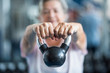 © Daniel - close up of senior holding a weight with his hands in front of the camera at the gym - adult woman working his body to be healthy