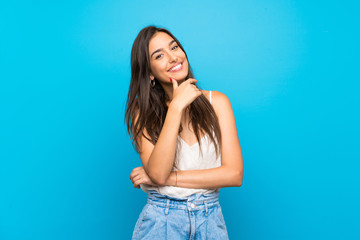 young woman over isolated blue background smiling