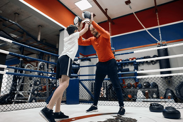 cheerful coach supporting his student to success, positive man and little boy giving high five to each other , full length photo. happiness, daddy wishes good luck to his kid before boxing