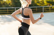 © Drobot Dean - Image of energetic fitness woman wearing tracksuit running outdoors