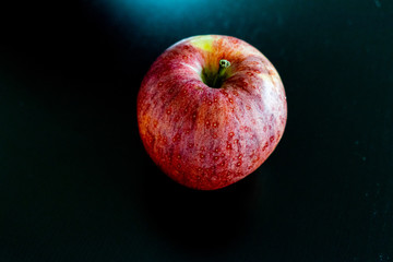 One isolated red apple on black background