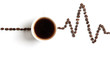 Cardiogram painted with coffee beans and cup of coffee on white background. The concept of the effect of caffeine on the heart.