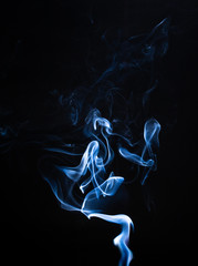 Smoke the blue incense on a black background. darkness concept