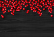 Christmas red holly berry on black wooden background