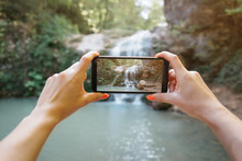 POV Of Hands Taking A Photo The Waterfall With Smartphone.