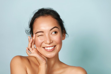skin care. woman with beauty face touching healthy facial skin portrait. beautiful smiling asian gir